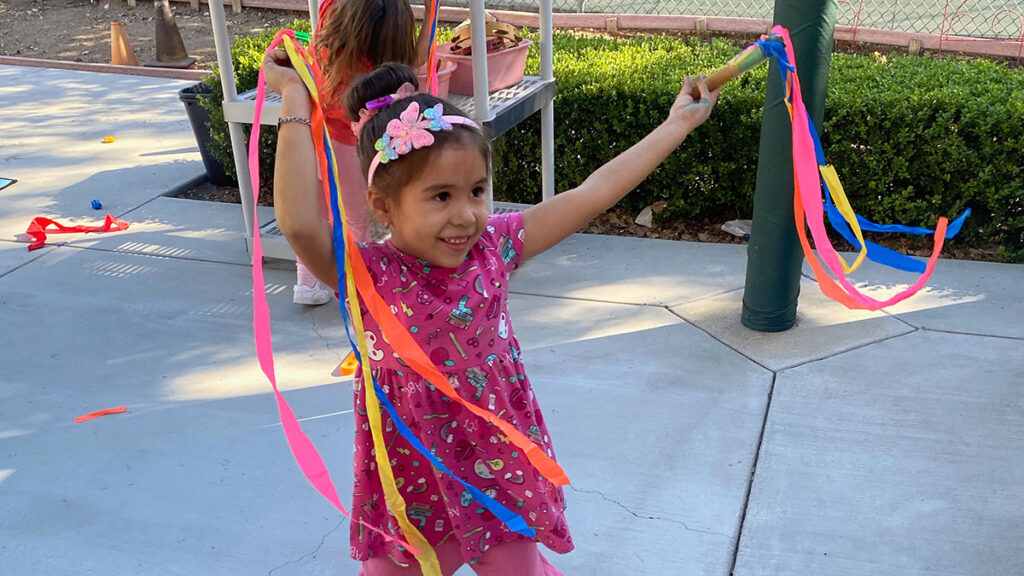 Child with ribbon toys